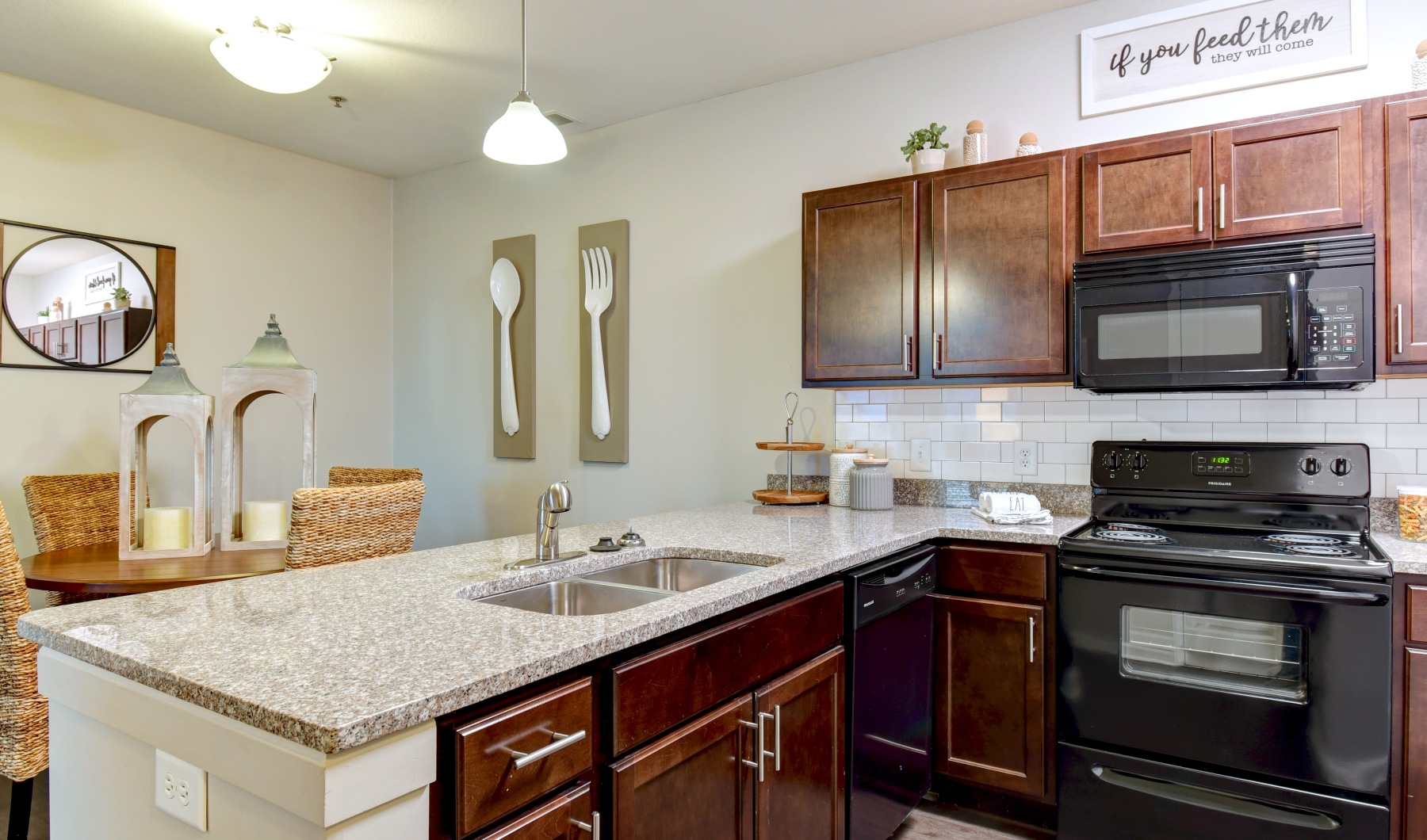 Modern apartments near Parkview Hospital Fort Wayne Kitchen with brown cabinets and black appliances