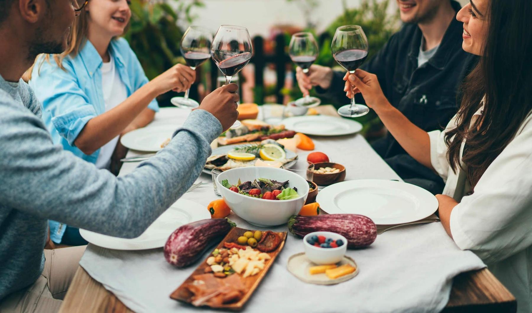 a group of people having a meal around an outdoor table