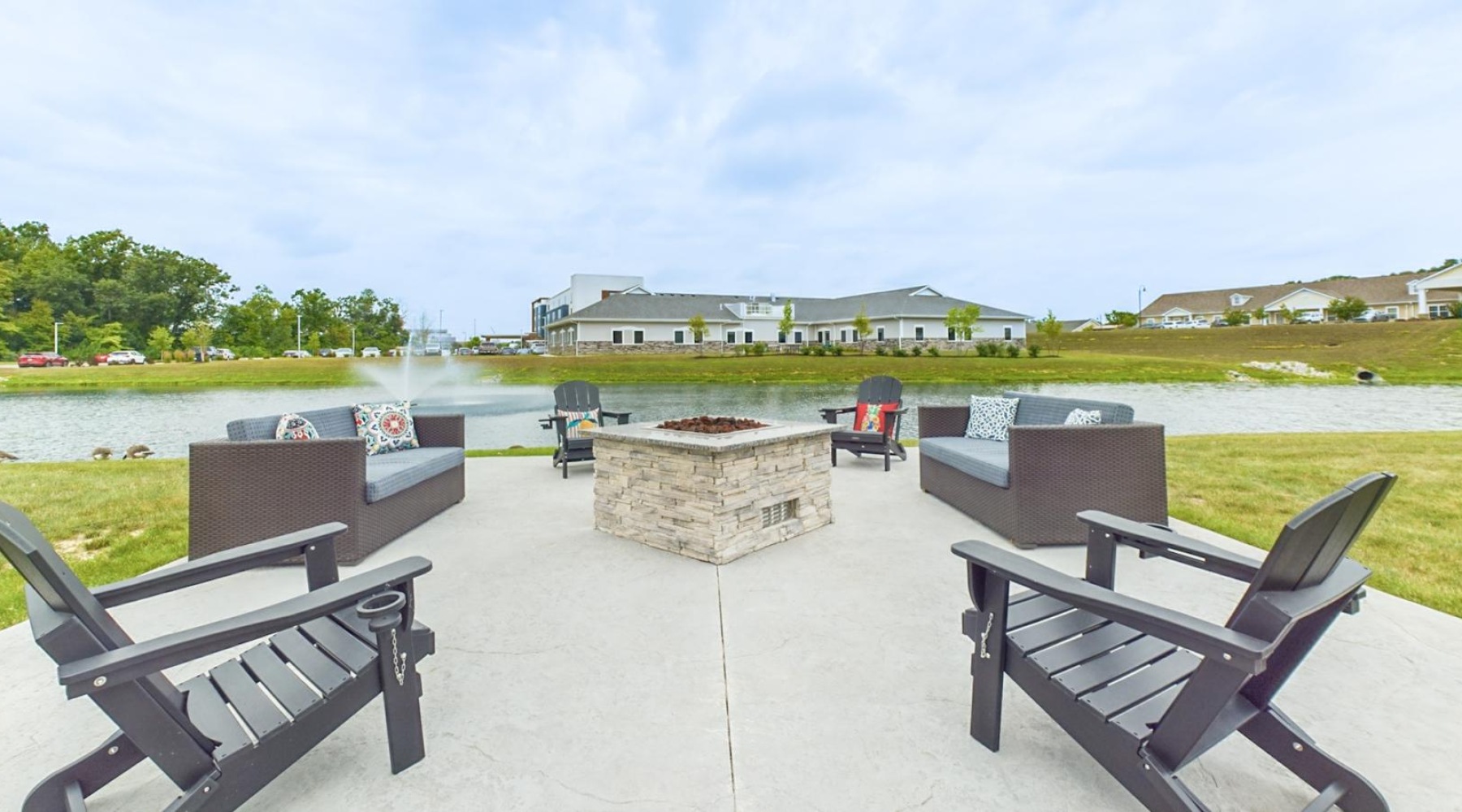The essence of exceptional living in Allen County a fire pit with chairs and a pond