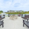 a fire pit with chairs and a pond